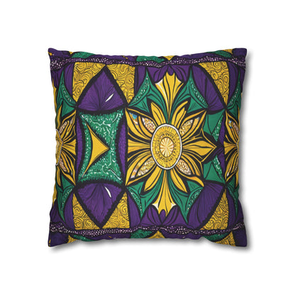 A rectangular pillow with bold, African-inspired patterns in purple, gold, green, and black. The design features a central star-like flower, swirling details, and repeating triangles and fan motifs on a white background.