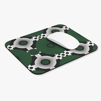 A white wireless mouse rests on a vibrant African-inspired mouse pad with bold green and white circular fans and black dots over a black background. The non-slip rubber base ensures stability, making this a modern, eye-catching desk accessory.