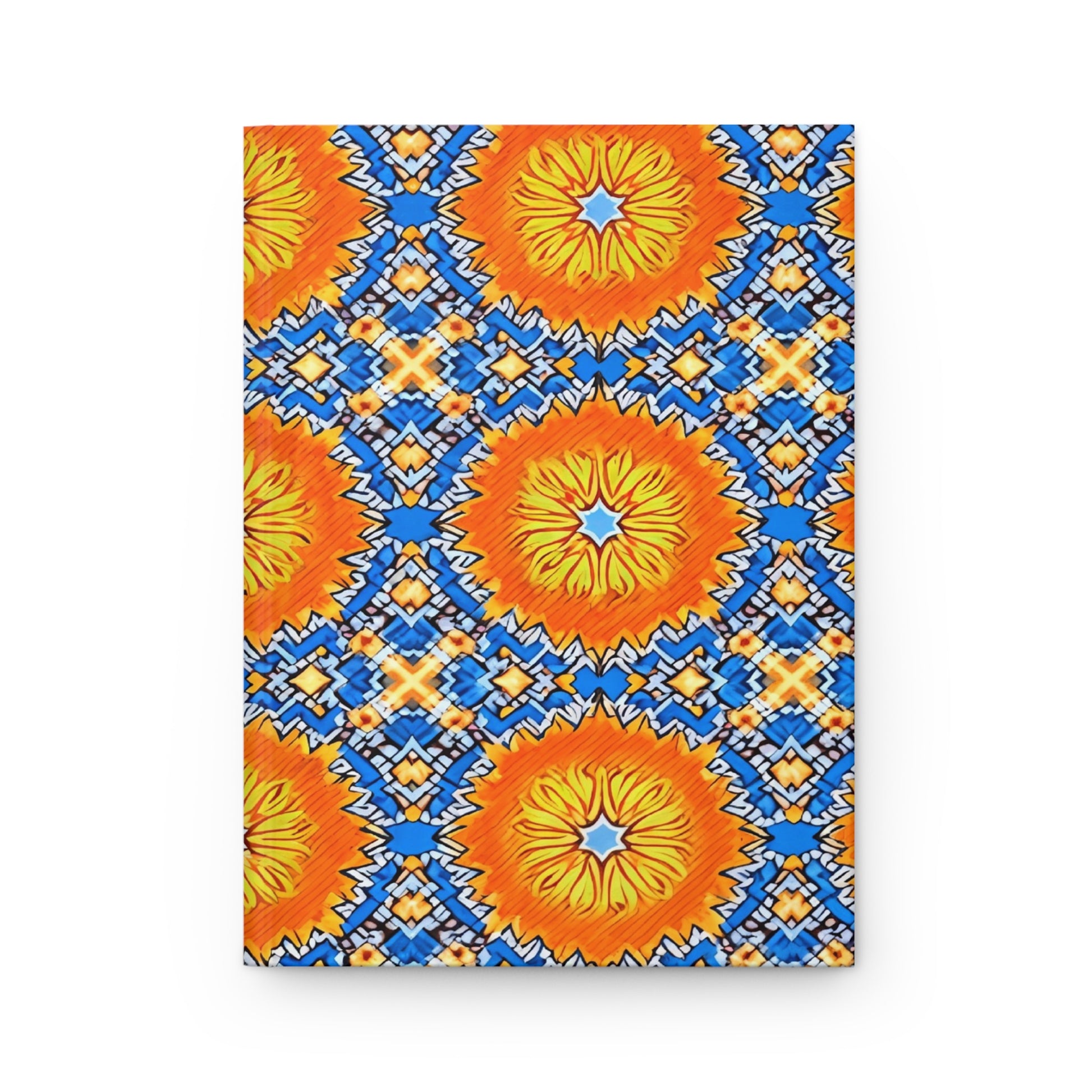 A vibrant geometric pattern inspired by African design features large, orange sunburst shapes with yellow centers on a blue background. This culturally-rich journal is accented with navy, white, and light blue diamonds in a striking, symmetrical motif.