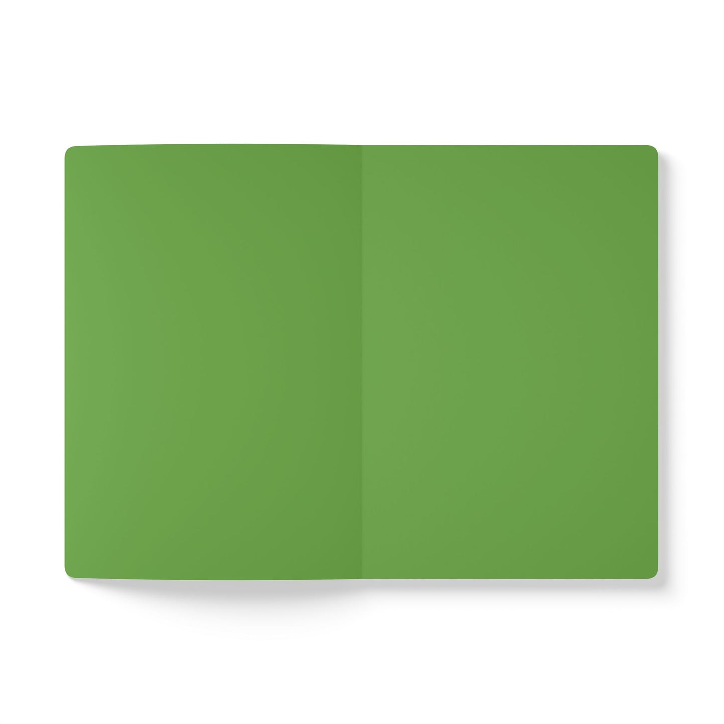 An open, blank African-inspired journal with green pages lies flat on a white background. The notebook’s center fold is visible, its edges are rounded, and the pages are perfect for creative journaling. The lighting is even and soft.