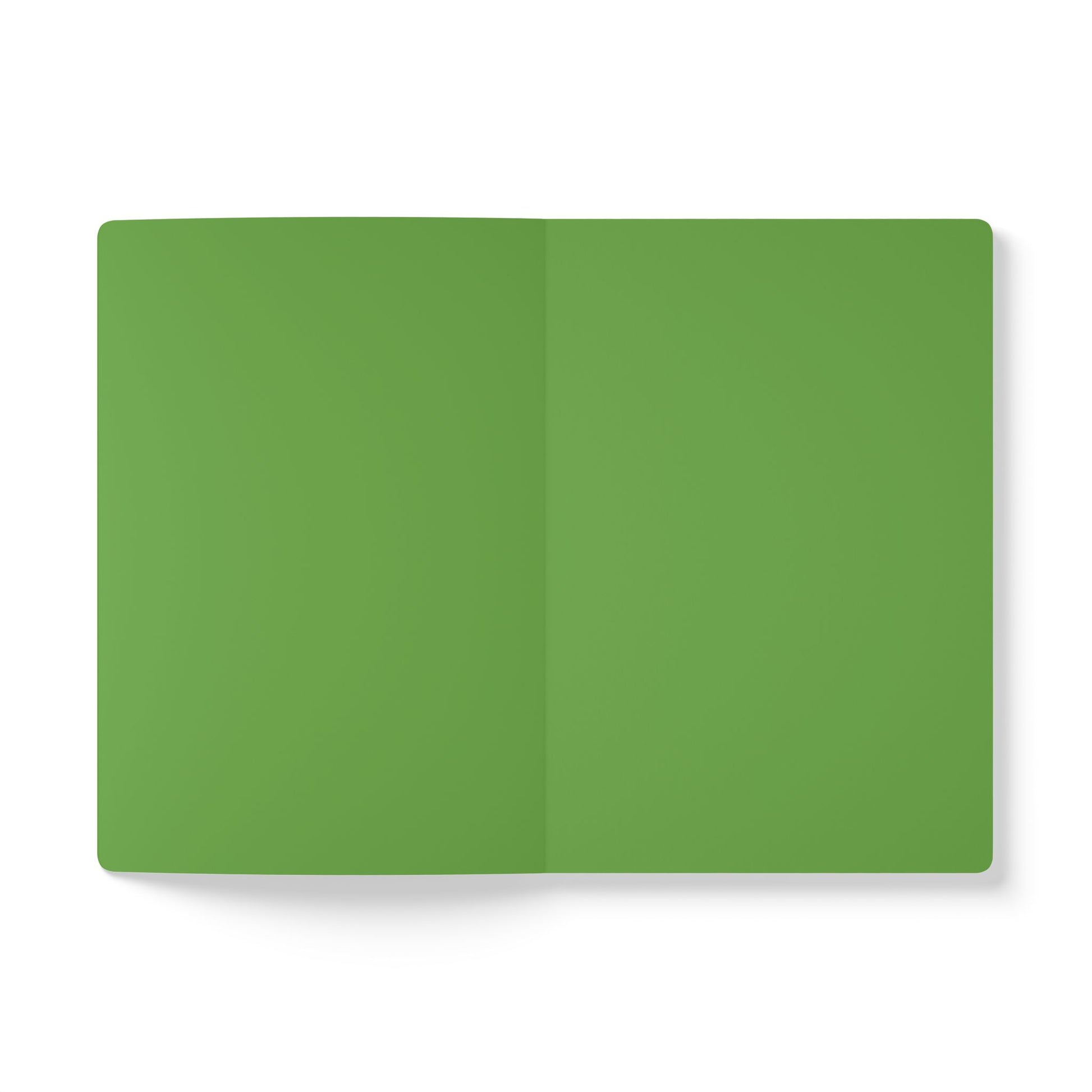 An open, blank African-inspired journal with green pages lies flat on a white background. The notebook’s center fold is visible, its edges are rounded, and the pages are perfect for creative journaling. The lighting is even and soft.