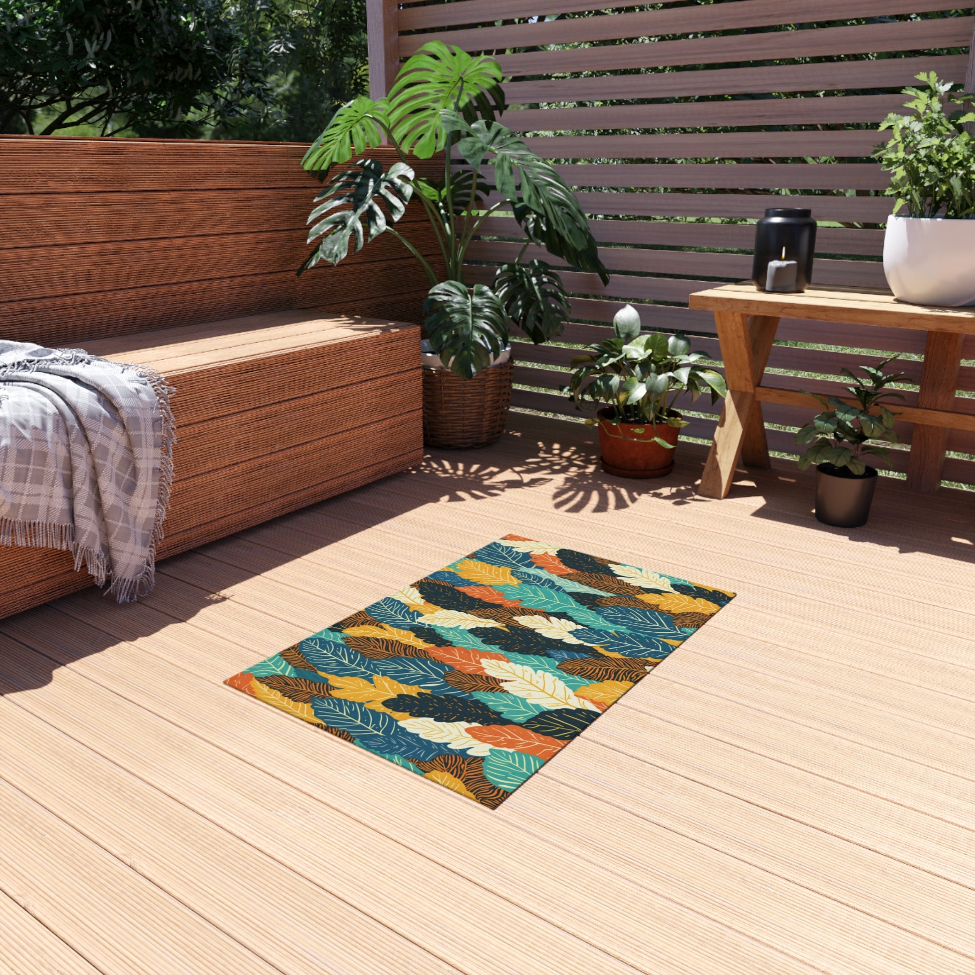 A wooden deck with an African-inspired tropical leaf-patterned rug, a built-in wooden bench with a gray throw, green potted plants, and a small table holding a coffee pot, mug, and plant; sunlight streams through a slatted privacy screen.
