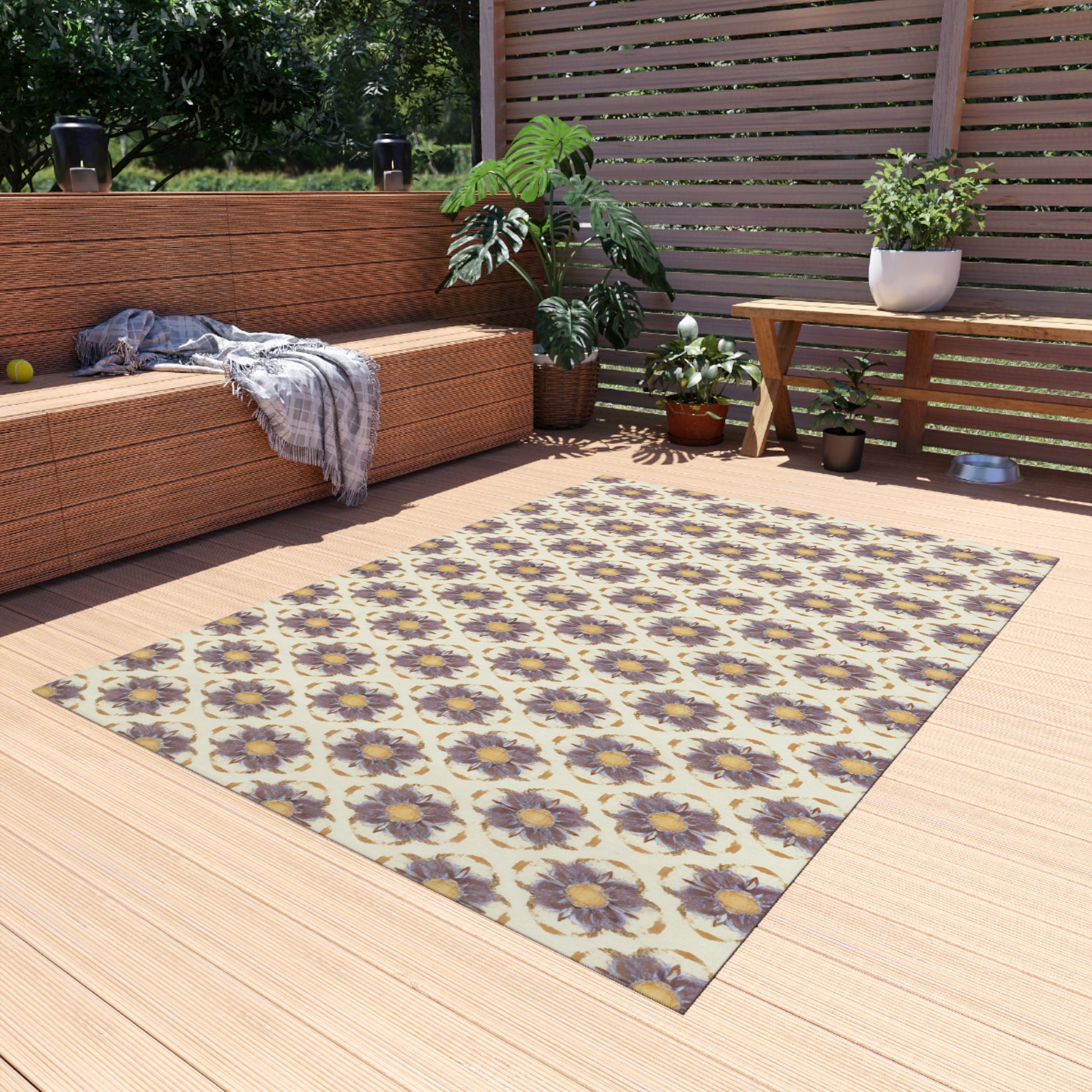 A cozy patio with wicker furniture, potted plants, and a patterned rug featuring African-inspired purple flowers on a light background. A plaid blanket is draped on the sofa, while sunlight filters through a slatted privacy screen behind the scene.