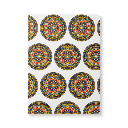 A white notebook cover features a repeating pattern of circular, colorful mandalas with intricate orange, blue, yellow, and black geometric designs—an African-inspired journal perfect for daily journaling.
