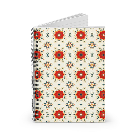 A vibrant journal with a spiral binding, this culturally inspired notebook features a repeating geometric floral pattern in red, orange, and green on a cream background. It stands upright with some pages slightly open at the top.