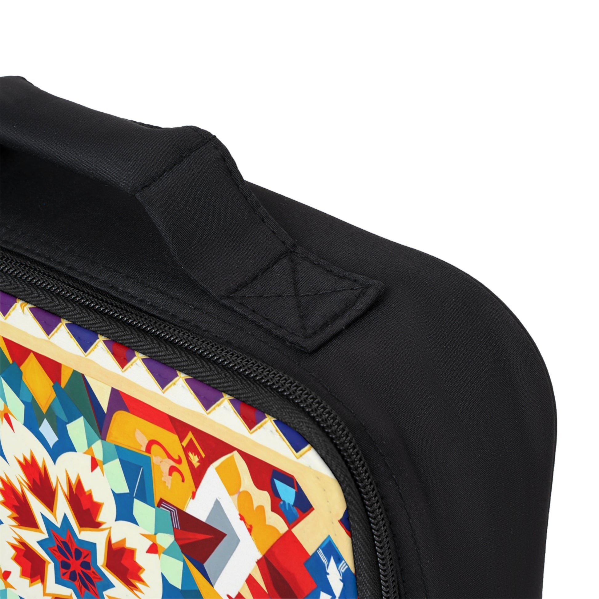 Close-up of an African-inspired lunch bag with a zippered edge and black fabric handle. The upper corner shows a colorful geometric star pattern with bold red, blue, yellow, and white details on the panel.
