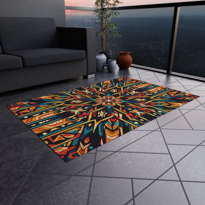 A vibrant African-inspired outdoor rug with a bold, geometric, multicolored pattern lies on gray tiled flooring of a modern balcony. A black sofa, potted plant, clay vases, and glass railing overlook a hazy cityscape at sunset.