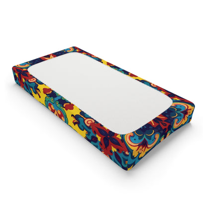A rectangular mattress with a plain white sleeping surface. The sides feature vibrant, African-inspired designs with swirling floral and leaf motifs, giving the mattress the lively look of custom changing pad covers.