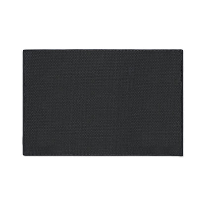 A rectangular black placemat with a subtle textured pattern and slightly rounded edges is shown on a white background. The design features visible stitching along the border and a small, repeating geometric or honeycomb detail, perfect for African-inspired décor.