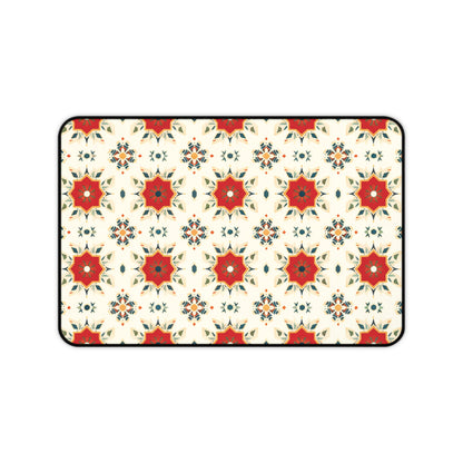 A rectangular Neoprene desk mat with a repeating geometric pattern features red eight-pointed stars with green and orange accents, surrounded by smaller floral and diamond shapes on a cream-colored background, all outlined in black—a colorful workspace accessory.