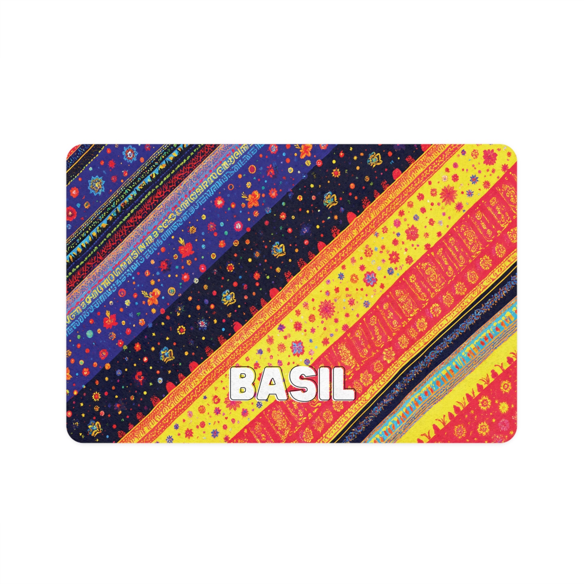 A rectangular card with colorful, African-inspired diagonal stripes in blue, black, red, yellow, and orange featuring floral and geometric patterns. The word BASIL appears in bold white letters near the bottom center. The background is plain white.