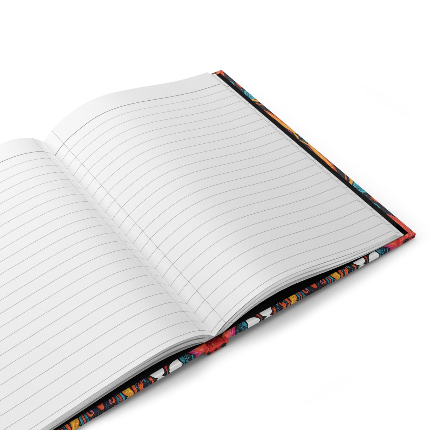 An open, lined writing journal rests on a white surface. The pages are blank, and the colorful patterned cover—partially visible around the edges—hints at an African-inspired hardcover journal with vibrant red, blue, and yellow tones.
