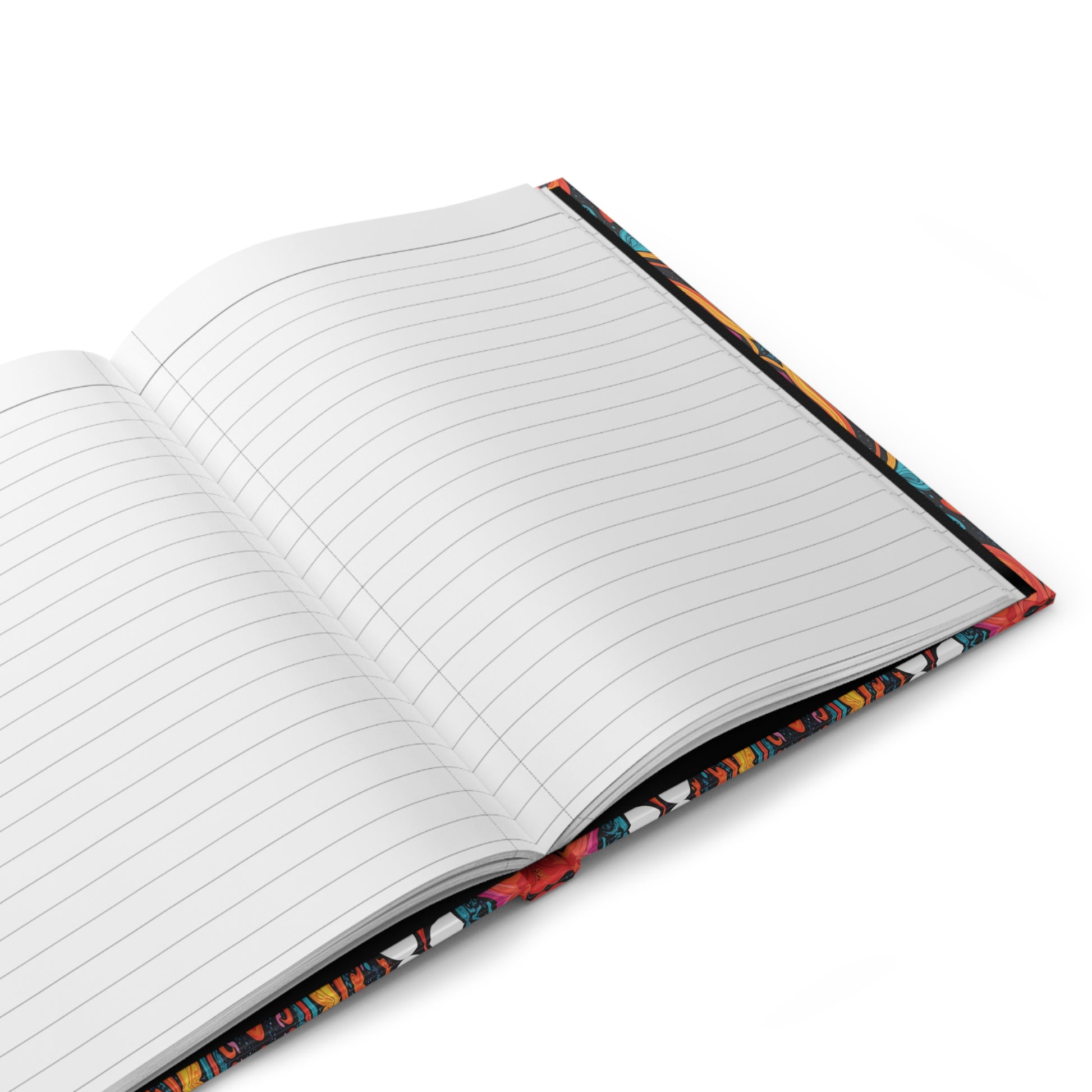An open, lined writing journal rests on a white surface. The pages are blank, and the colorful patterned cover—partially visible around the edges—hints at an African-inspired hardcover journal with vibrant red, blue, and yellow tones.