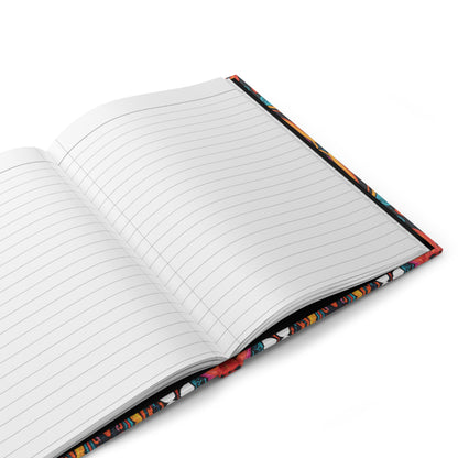 An open, lined writing journal rests on a white surface. The pages are blank, and the colorful patterned cover—partially visible around the edges—hints at an African-inspired hardcover journal with vibrant red, blue, and yellow tones.