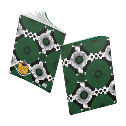 Two composition notebooks with black, white, and green geometric floral covers are shown. Perfect as an African-inspired journal for daily journaling, one is open to reveal white pages; the other is closed with a yellow label and barcode sticker on the cover.