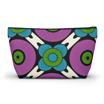 A vibrant cosmetic travel bag with a bold, symmetrical pattern of large purple circles and blue-green stylized flowers, accented by African-inspired patterns in black and white. This retro, geometric T-bottom pouch offers striking visual appeal.