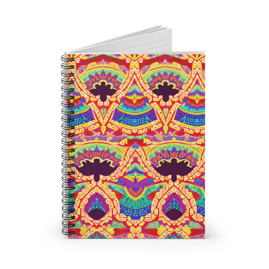 A spiral notebook with a cover featuring vibrant, symmetrical, culturally inspired designs in red, yellow, blue, orange, and purple. The intricate, abstract pattern resembles traditional or bohemian motifs. The notebook is standing upright and open slightly.