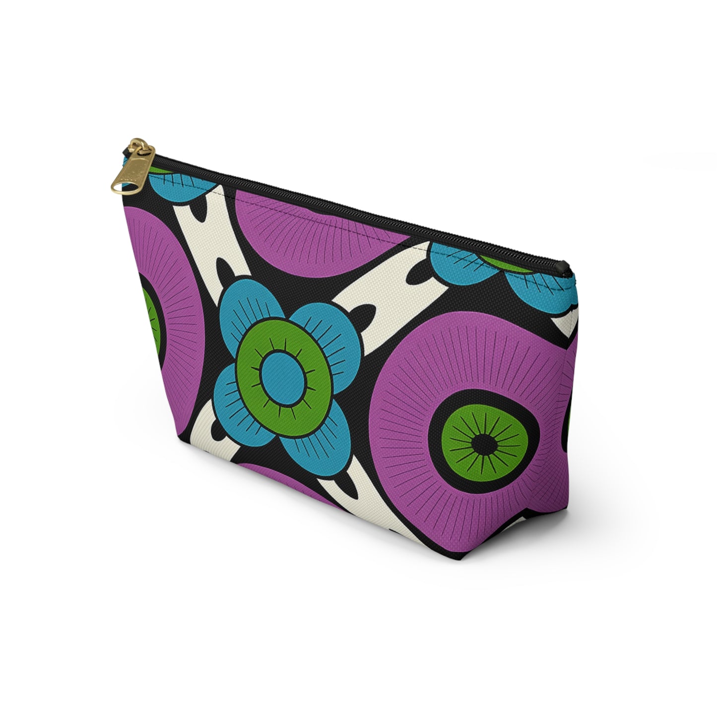 A T-bottom pouch with a bold, colorful floral pattern inspired by African-inspired patterns. Large purple, blue, and green flowers with black centers pop against a white and black background. Gold zipper closure; stands upright to showcase its unique triangular shape.