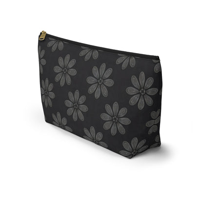 A black T-bottom pouch with large gray, African-inspired floral patterns—each flower boasting eight textured petals. The gold-colored zipper adds elegance, making this cosmetic travel bag stand upright on a white background.