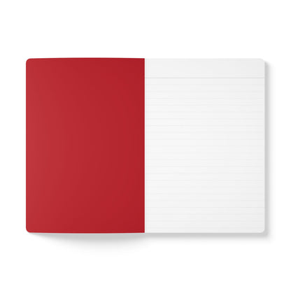 An open creative journal lies flat on a white surface. The left side shows a solid red inner cover, while the right displays a lined white page. The lines are evenly spaced, creating a clean, minimalistic look perfect for daily journaling.