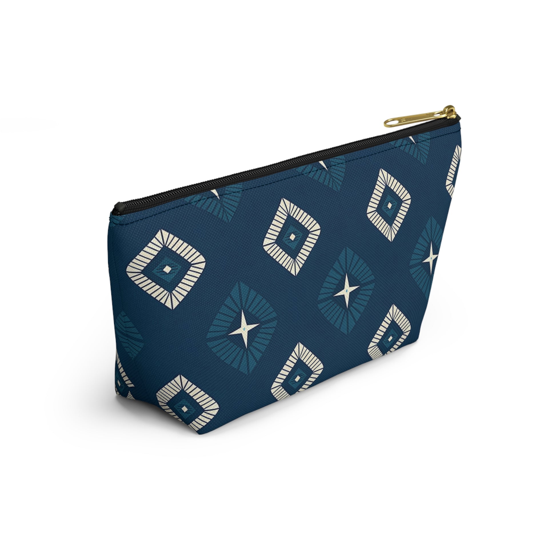 A blue cosmetic travel bag with a gold zipper, featuring African-inspired patterns in a geometric diamond design of white and navy. The T-bottom pouch stands upright, displaying radiating lines and star shapes at each center against a white background.