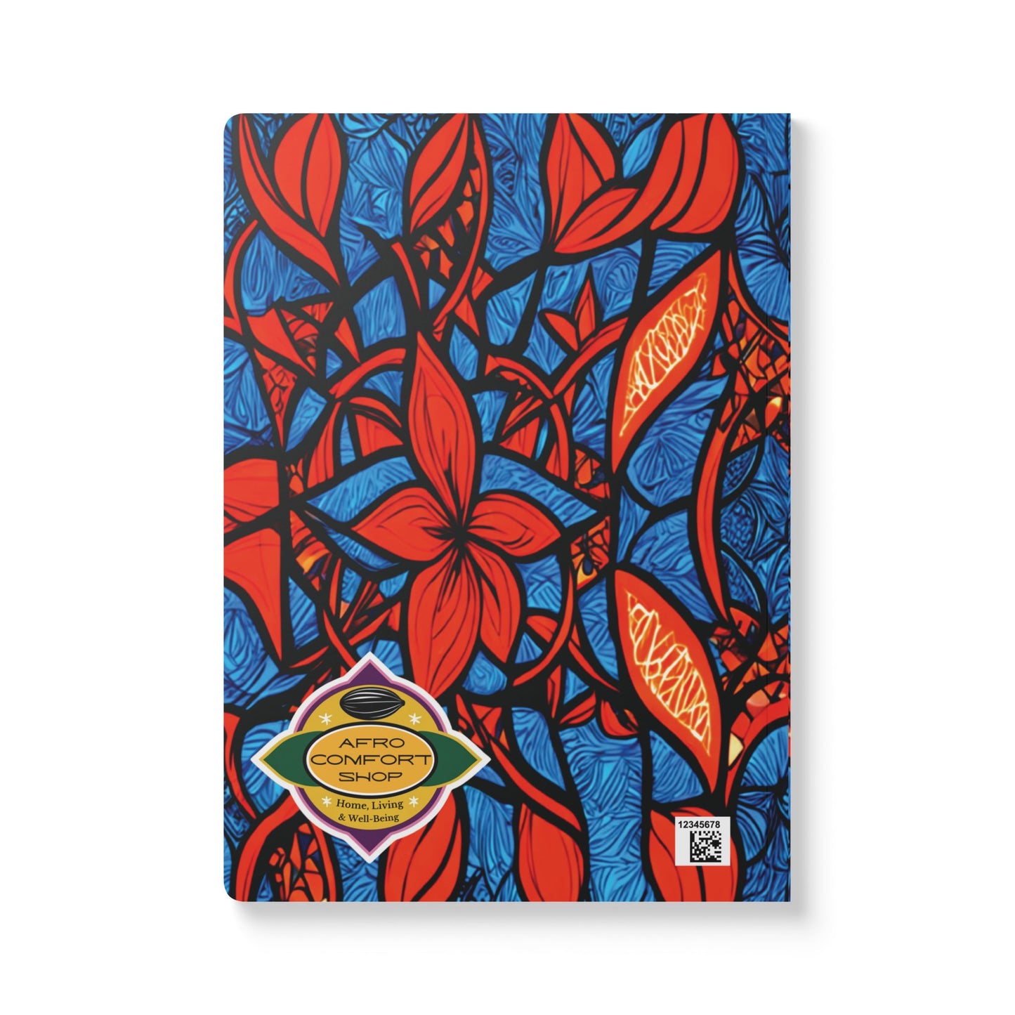 A vibrant African-inspired journal with bold red leaves and flowers outlined in black over a blue textured cover. A yellow and green “AFRO COMFORT SHOP Home Linen” label and QR code accent the creative notebook’s eye-catching design.