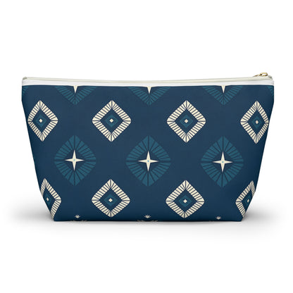 A modern, symmetrical T-bottom pouch featuring African-inspired patterns of cream and blue diamonds on a dark blue background. This cosmetic travel bag has a gold zipper and flat base, allowing it to stand upright stylishly.