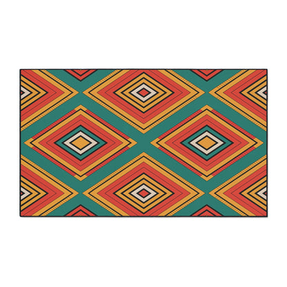 A rectangular rug features a bold geometric pattern of overlapping diamond shapes in red, orange, yellow, and teal, drawing on African-inspired aesthetics. The symmetrical design creates a vibrant, eye-catching look with depth and movement.