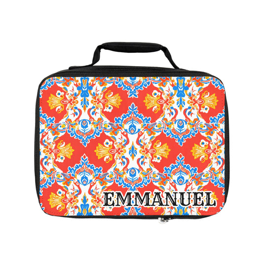 This personalized lunch bag features an African-inspired ornate floral pattern in red, blue, yellow, and white. Its insulated design and black handle make it both stylish and practical. “EMMANUEL” appears in bold black-and-white lettering on the front.