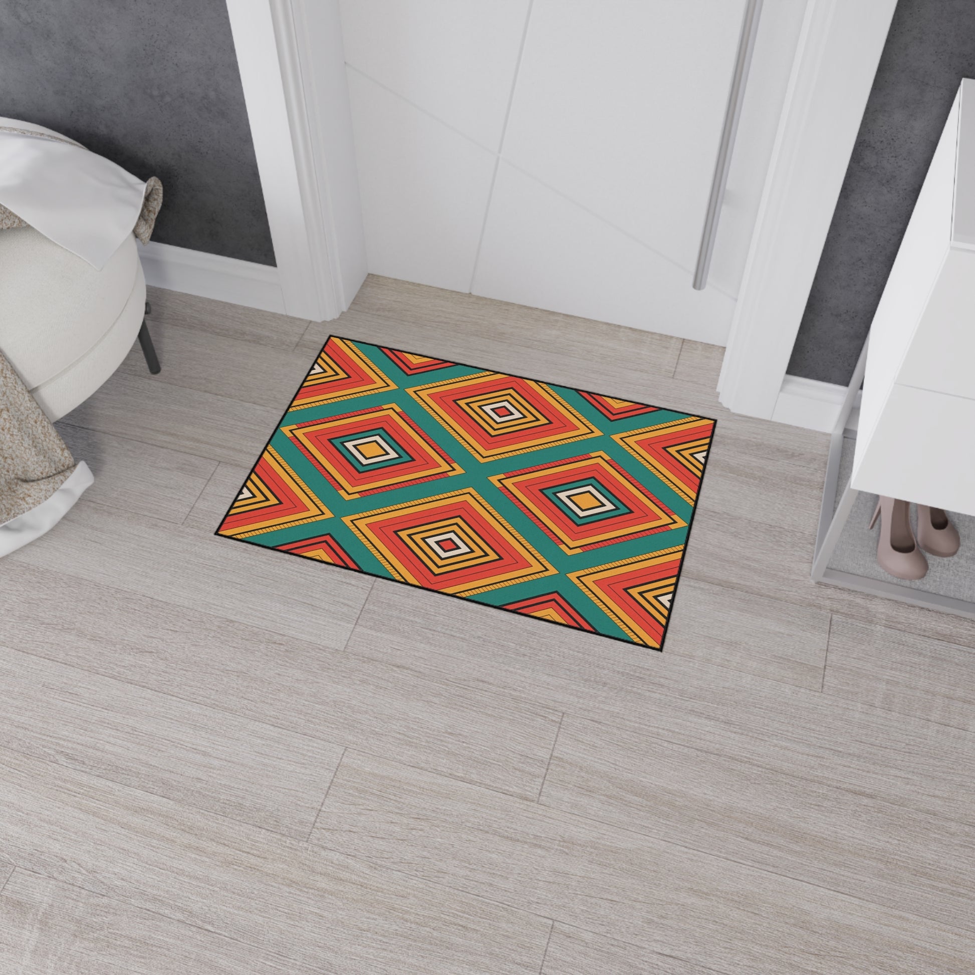 A colorful, non-slip doormat with a bold geometric diamond pattern in red, orange, yellow, blue, and black sits on light wood-look tile flooring near a white wall, a bedroom, and a small white cabinet with beige high-heeled shoes underneath.