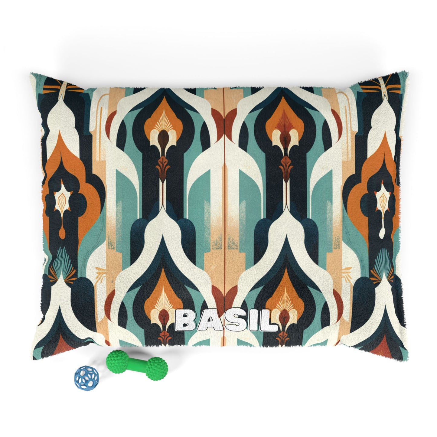 A cozy pet bed with a retro geometric pattern in teal, orange, cream, and brown. BASIL is printed boldly on the front of this personalized pet bed. Next to it are a green textured chew toy and a blue ball-shaped toy.