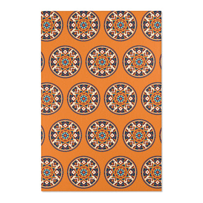 A rectangular mat with an orange background featuring a repeating pattern of African-inspired, mandala-like designs in blue, red, white, and black. The circles are evenly spaced in a grid layout, creating a vibrant geometric look.