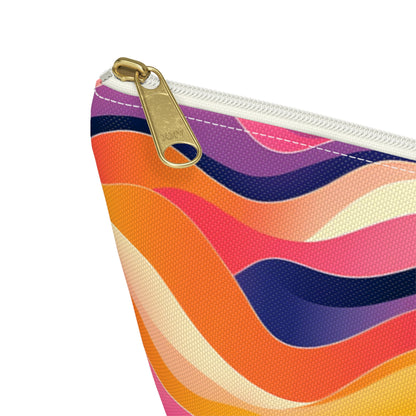 A close-up of a T-bottom pouch with a gold zipper. The fabric showcases vibrant, African-inspired patterns in shades of orange, pink, purple, cream, and navy blue. The woven texture is clearly visible, adding depth to this stylish cosmetic travel bag.