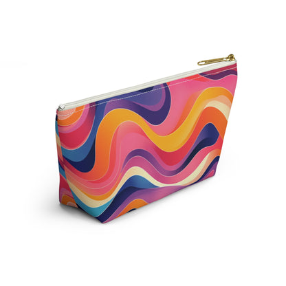 A zippered cosmetic travel bag with a gold zipper, featuring a vibrant, wavy abstract pattern inspired by African-inspired patterns in pink, orange, yellow, purple, blue, and white. The T-bottom pouch design gives it a modern and lively appearance.