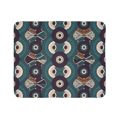 A geometric pattern featuring circular shapes with radiating lines, stylized eyes, and diamond-like motifs. Inspired by African-inspired fleece blankets, this design uses teal, cream, brown, and dark purple for visually intricate cozy home decor.