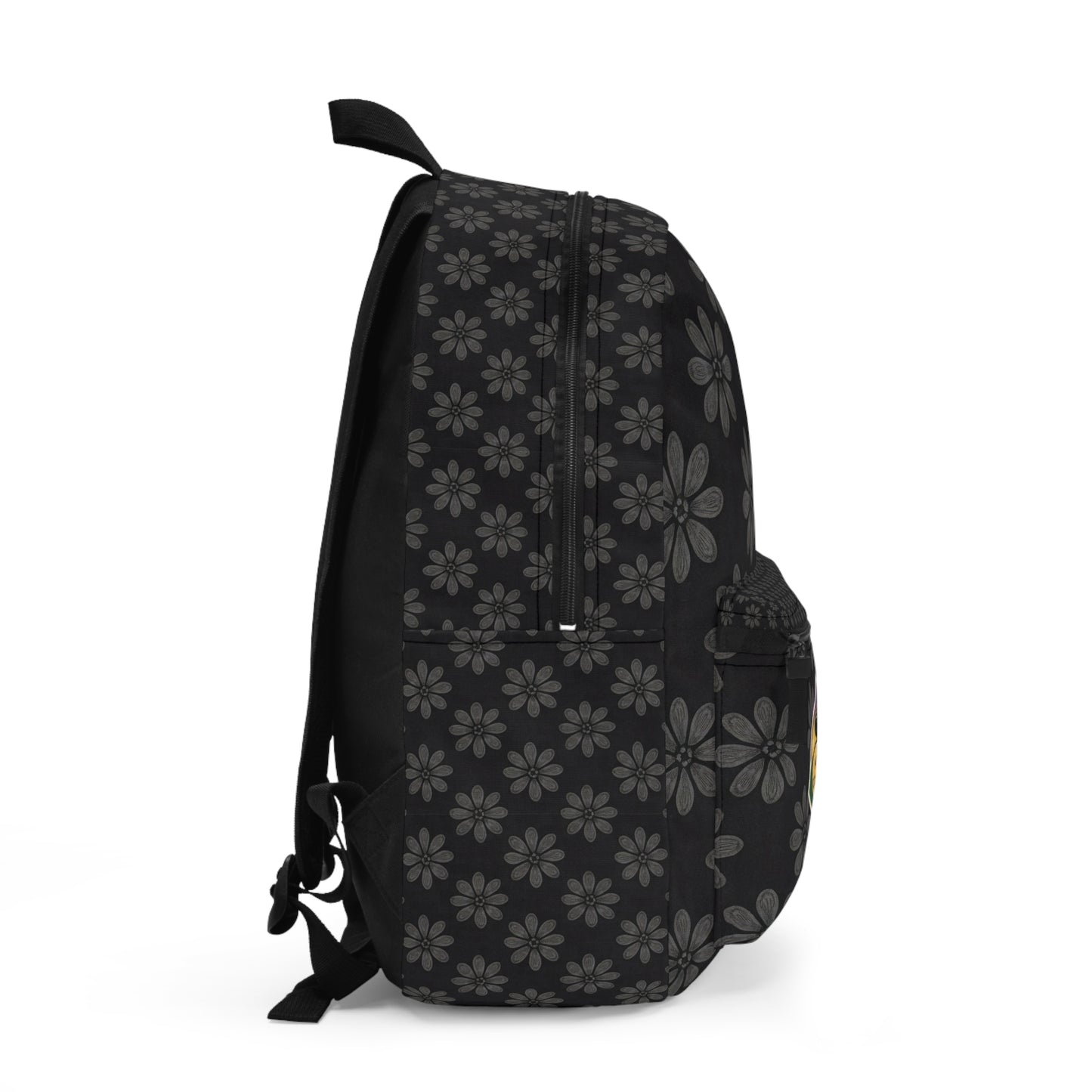 A black boho chic rucksack viewed from the side, featuring a repeating pattern of gray daisy-like flowers. The bag has a front pocket, mesh side pocket, zippers on top, and adjustable shoulder straps visible on the left. Plain white background.