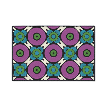 A rectangular rug with African-inspired aesthetics features a repeating geometric floral pattern. Large purple circles with green centers are surrounded by blue petals on a cream background, forming symmetrical, bold rows—perfect for adding unique style to your space.