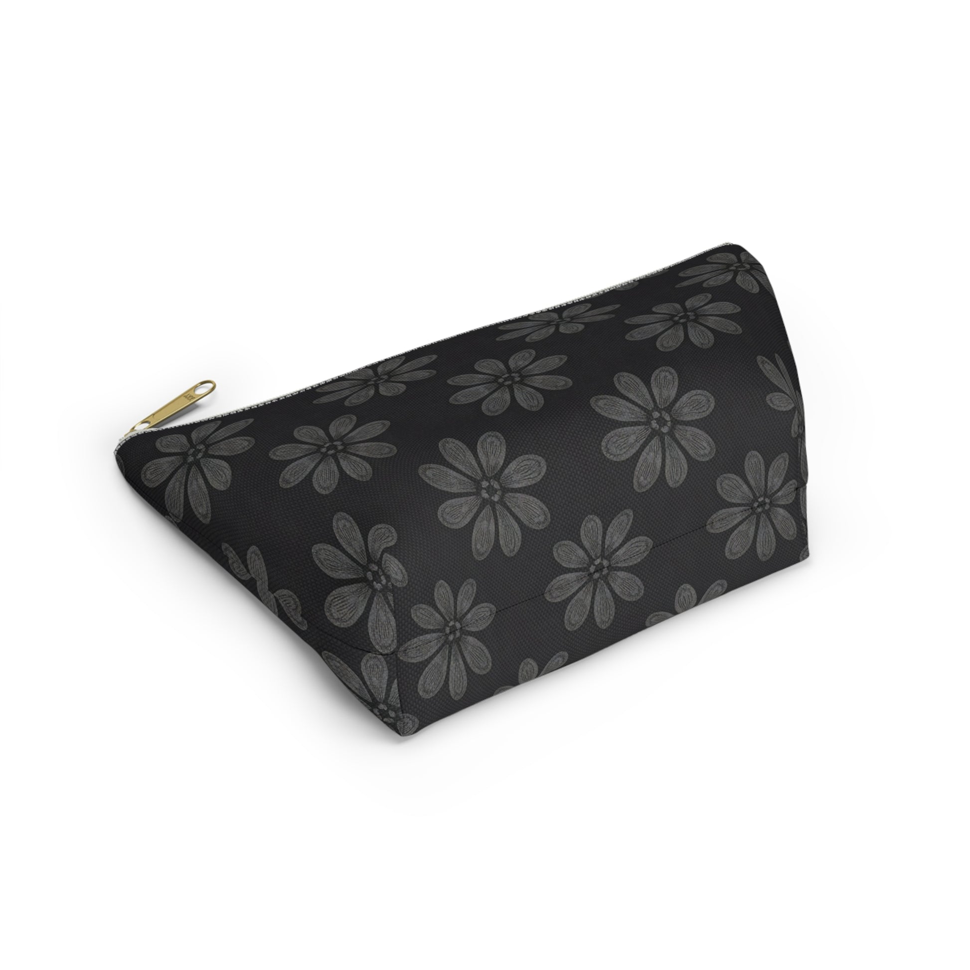 A black T-bottom pouch with a gold zipper pull, featuring gray, stylized six-petaled flowers in African-inspired patterns. The cosmetic travel bag is photographed on a white background, angled to highlight its triangular side and striking floral design.