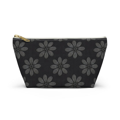 A black cosmetic travel bag with a gold zipper, featuring an African-inspired pattern of large, gray six-petal flowers. The T-bottom pouch's symmetrical floral design creates a strikingly elegant and organized appearance.