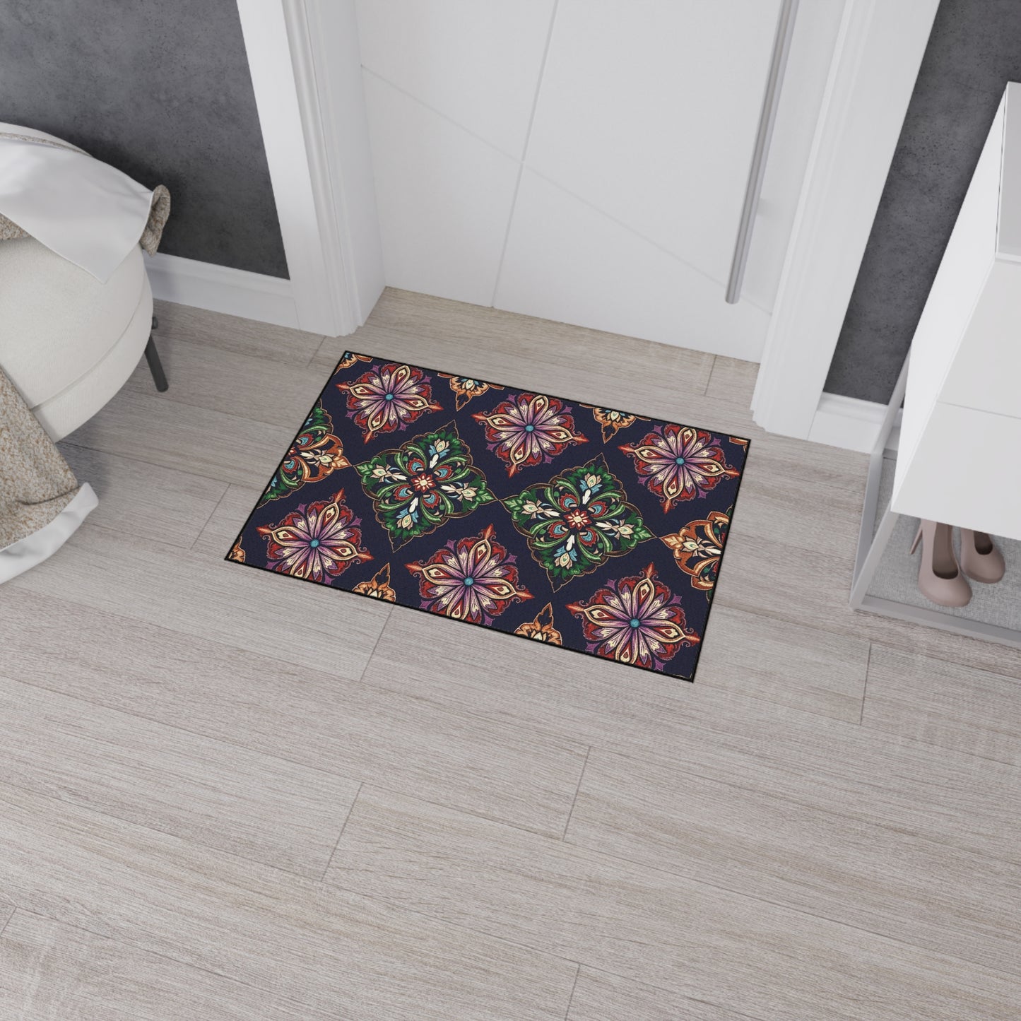 A colorful doormat with a geometric floral pattern in red, green, gold, and purple sits on light wood flooring at the entrance, adding an African-inspired home decor touch. Its non-slip rubber backing keeps it secure in this modern room.