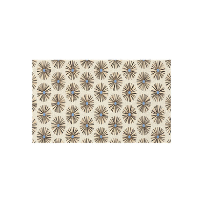 A beige rectangle features a repeating pattern of dark brown, starburst-like shapes with small blue dots at their centers, echoing authentic African art designs. The overall look is geometric and symmetrical—perfect for African-inspired outdoor rugs.
