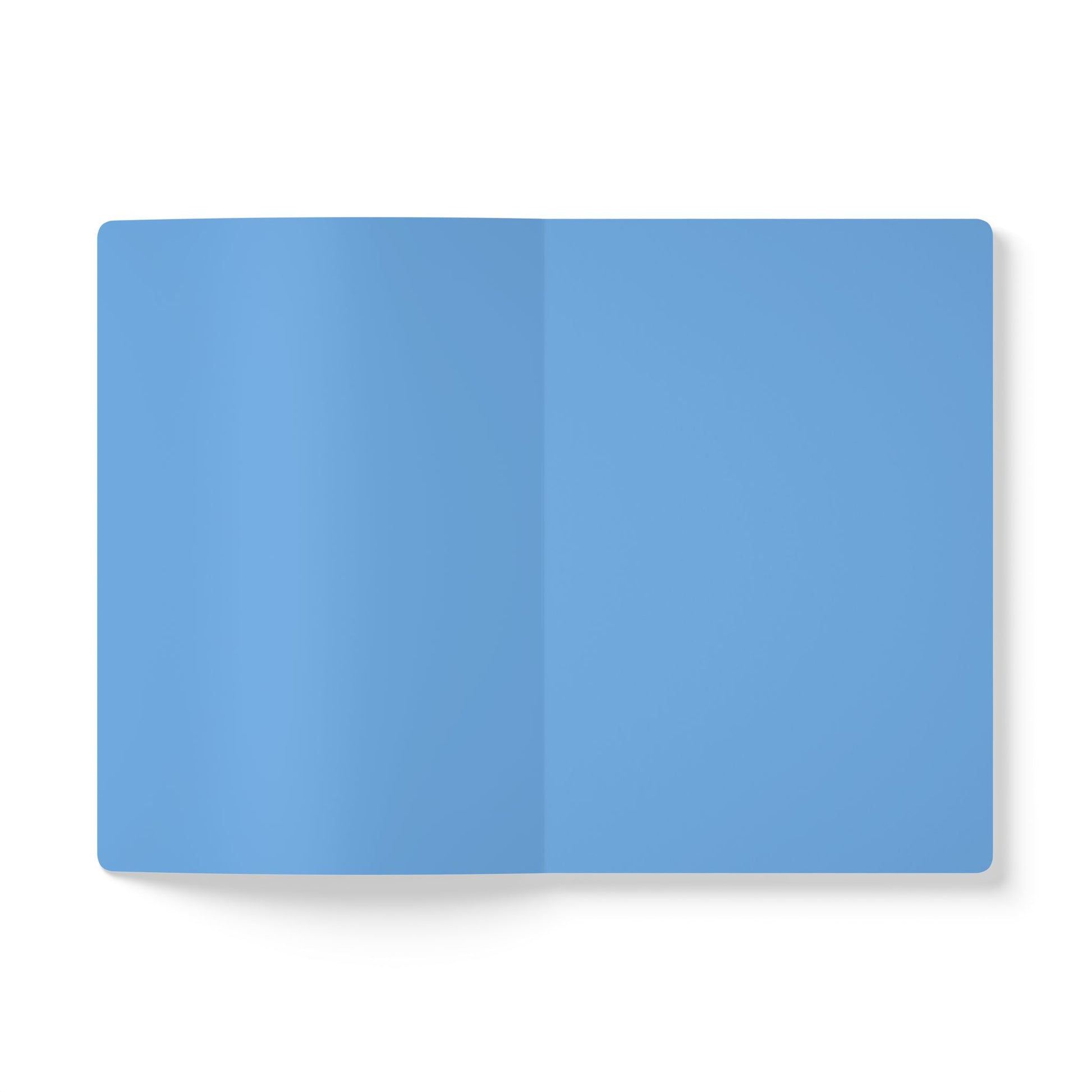 An open, blank creative journal with light blue pages is displayed against a white background. The notebook lies flat, showing a center fold and no text or markings. Shadows on the left add depth to this inviting space for daily journaling.