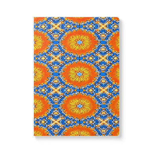 A vibrant African-inspired journal with a geometric sunburst pattern in bright orange and yellow, accented by bold blue, white, and orange diamond motifs—perfect for creative journaling or as a colorful travel diary. The background is white.