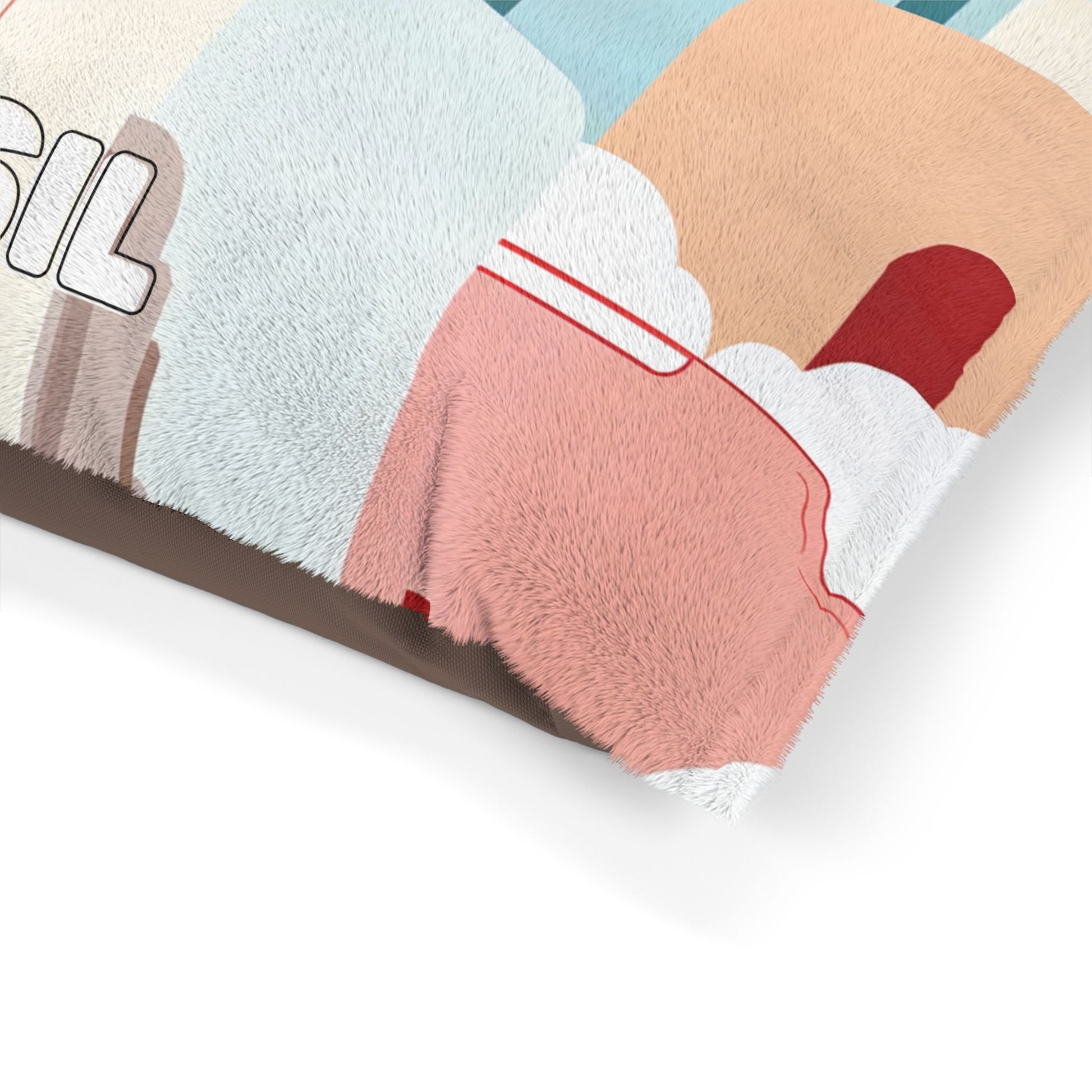 Close-up of a soft, fuzzy blanket with an abstract, African-inspired illustration featuring pastel blocks of tan, blue, pink, and red plus white cloud shapes. Partial bold black letters SIL appear on the left side. Blanket edges are fluffy and textured.