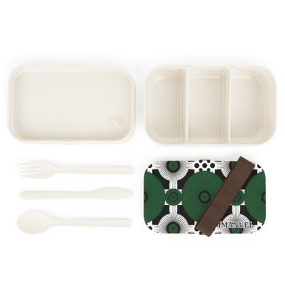 An African-inspired bento lunch box set featuring a white tray with three sections, a matching lid in green and black geometry, a brown elastic band, and BPA-free fork, spoon, and knife—all arranged neatly on a white background.