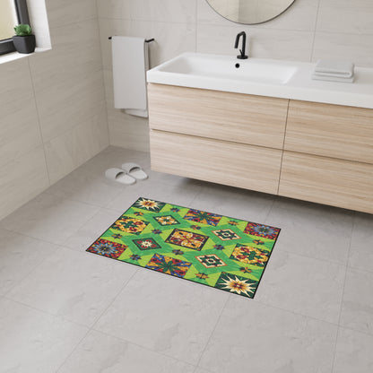 A modern bathroom with beige tiled walls and floor, a white sink with wood cabinets, a round mirror, white slippers, towel, and a vibrant green geometric-patterned mat featuring African-inspired aesthetics and non-slip rubber backing at the center.