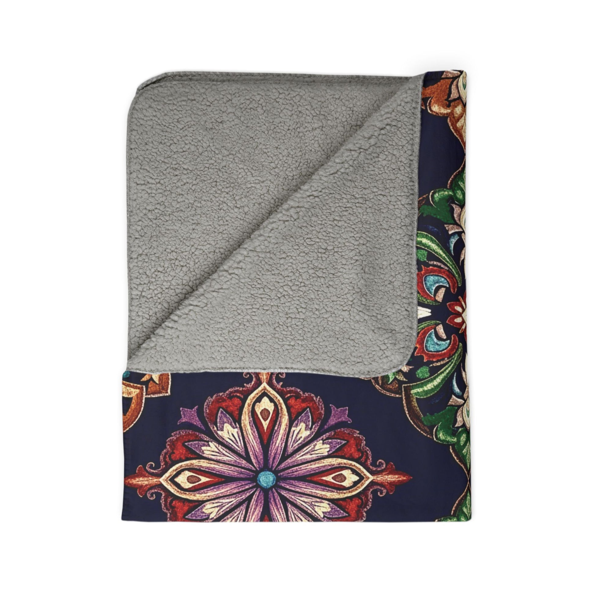A folded sherpa fleece blanket with a soft, plush gray underside and a top side featuring an intricate, multicolored mandala pattern on a dark blue background. One corner is folded over, perfect as cozy home decor.