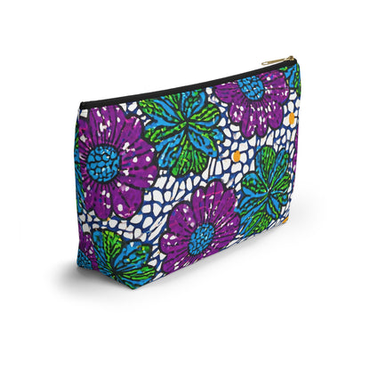 A versatile organizer, this T-bottom cosmetic bag features a bold pattern of purple and green flowers with blue centers, accented by yellow dots on a white mosaic-like background. The gold zipper adds elegance to this African-inspired pouch.
