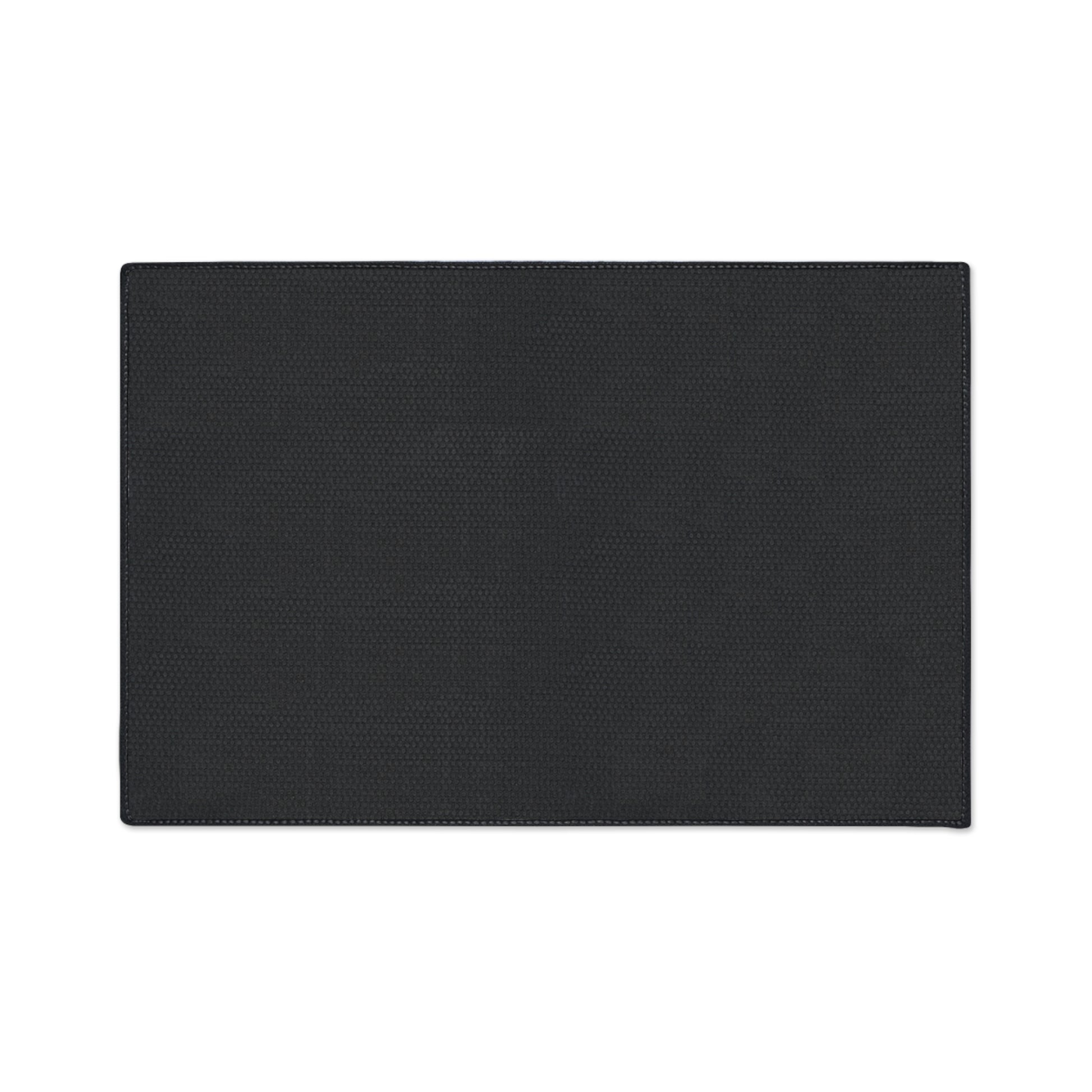 A rectangular, flat black non-slip rug with subtle textured patterns is centered on a white background. The edges are neatly stitched, and its surface appears smooth and even. The mat has no visible designs or logos.