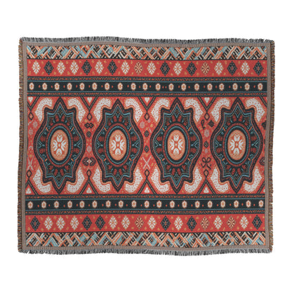 A rectangular rug features an African-inspired, symmetrical geometric pattern in red, black, teal, and cream. Three large star medallions run lengthwise, surrounded by diamonds and small motifs. Fringed edges line the shorter sides in this traditional ornate design.